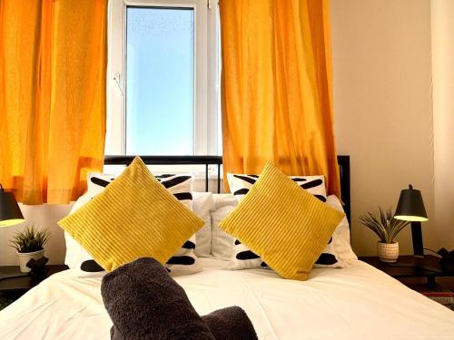 a bed with two yellow pillows and a window at Central Station Apartment in Central Station