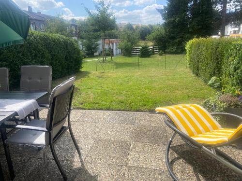 two chairs and a table on a patio with a yard at Ferienwohnung-fein in Bad Sachsa