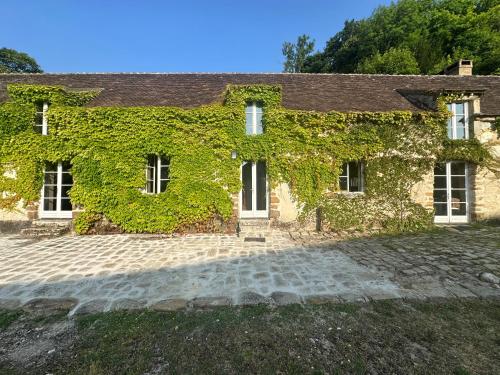 an ivy covered house with a cobblestone driveway at Ferme du Haute du Château in Villecerf