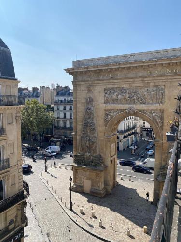 an archway in a city with pigeons on a street at Hôtel Allety in Paris