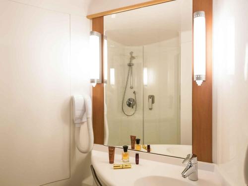 a white bathroom with a sink and a shower at ibis Esch Belval in Esch-sur-Alzette