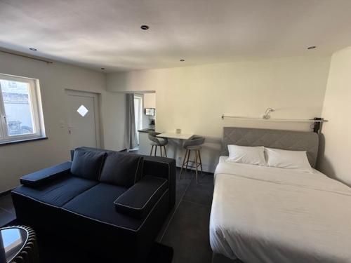 Un dormitorio con una cama y un sofá azul. en Melo, en Plombières