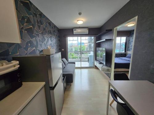 een keuken met een woonkamer en een kamer met een bank bij Infinity Blue, High Speed Wi-Fi, Soft bed in Udon Thani