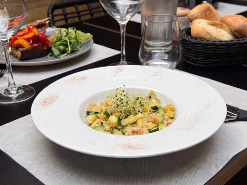 a white bowl of food on a table with plates of food at ibis Nîmes Ouest - A9 in Nîmes