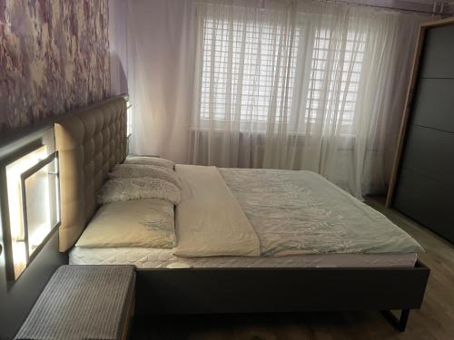 ein Bett in einem Schlafzimmer mit Fenster in der Unterkunft Big apartment for four in Klaipėda