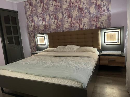 ein Schlafzimmer mit einem großen Bett mit einem Gemälde an der Wand in der Unterkunft Big apartment for four in Klaipėda
