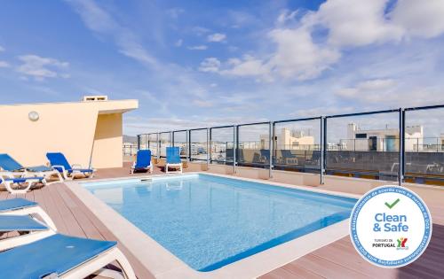 a swimming pool on the roof of a building at Village Marina Olhão in Olhão