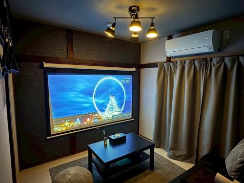 a living room with a large screen tv in a room at M&T stay in Tokyo
