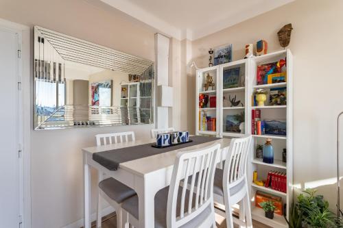 a dining room with a white table and chairs at Magnifique appartement climatisé vue mer in Toulon