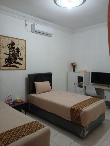 Ένα ή περισσότερα κρεβάτια σε δωμάτιο στο Ndalem Surya Malioboro