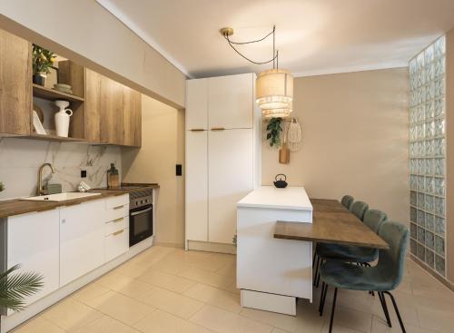 a kitchen with white cabinets and a table and chairs at Dona Marieta House in Vilamoura