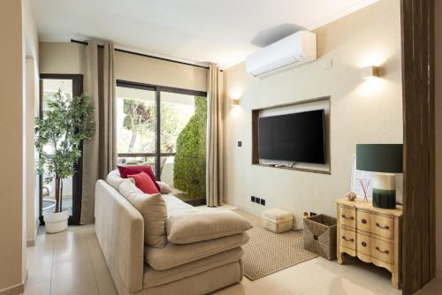 a living room with a couch and a tv at Dona Marieta House in Vilamoura