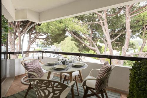 a table and chairs on a balcony with trees at Dona Marieta House in Vilamoura
