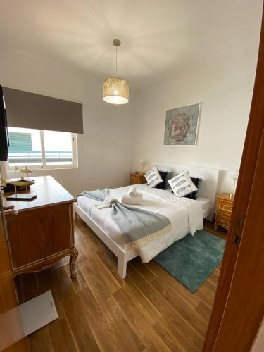 a bedroom with a large bed and a desk at Neptuno IV - Vilamoura in Quarteira