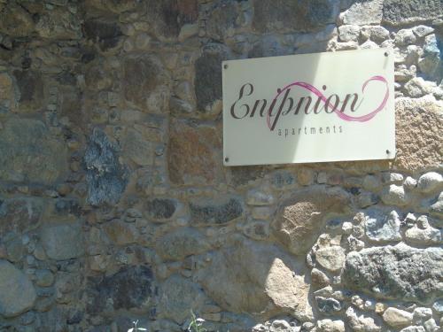 a sign on the side of a stone wall at Enipnion Apartments in Kakopetria