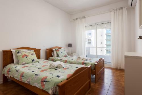 ein Schlafzimmer mit zwei Betten und einem Fenster in der Unterkunft Maresia - Front beach - Quarteira in Vilamoura
