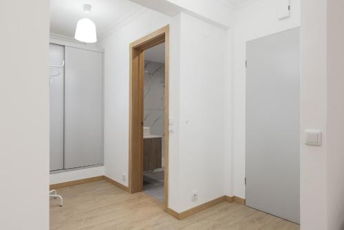 ein leeres Zimmer mit weißen Wänden und einem Spiegel in der Unterkunft Miral Beachside 4 - by HD Properties in Caliços