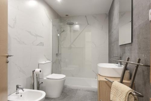 ein Badezimmer mit Toilette, Waschbecken und Dusche in der Unterkunft Miral Beachside 1 - by HD Properties in Caliços