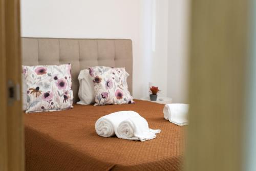 ein Bett mit Handtüchern und Kissen darauf in der Unterkunft Miral Beachside 1 - by HD Properties in Caliços