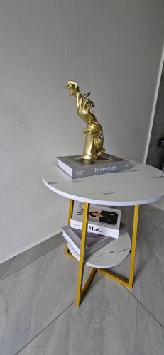 Una mesa con una estatua de oro encima. en DREAMS INN guest house, en Maun