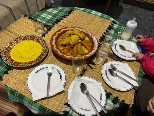 une table avec des assiettes blanches et un bol de nourriture dans l'établissement Auberge Tafouyt, à Tamtetoucht
