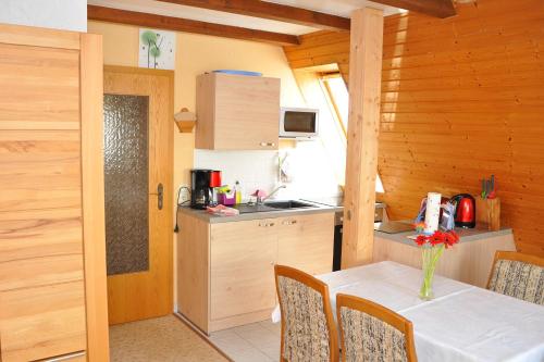 eine Küche mit einem Tisch mit einer Vase mit Blumen darauf in der Unterkunft Ferienwohnung Neubert in Wolkenstein