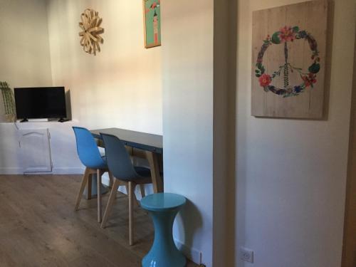 une salle à manger avec une table et des chaises bleues dans l'établissement Lilloise Home, à Lille