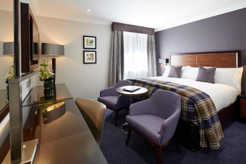 a hotel room with a bed and a table and chairs at Sir Christopher Wren Hotel in Windsor