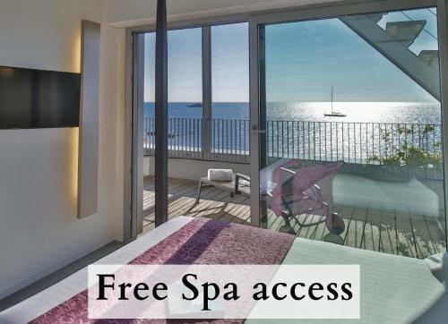 a bedroom with a balcony with a view of the ocean at Royal Antibes - Luxury Hotel, Résidence, Beach & Spa in Antibes