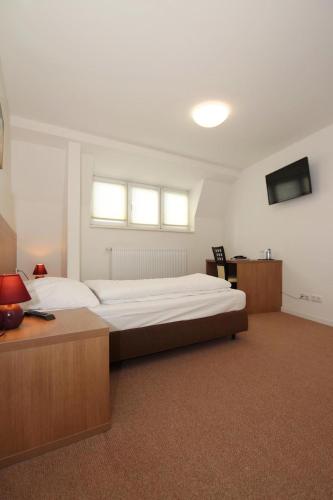 a large bedroom with a large bed and a desk at Apartment Hotel am Sand 24H Self Check-in in Hamburg