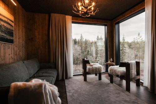 a living room with a couch and a large window at SkyView Igloo Resort in Rovaniemi