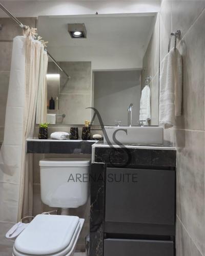 a bathroom with a white toilet and a sink at Arena Suite LR in La Rioja