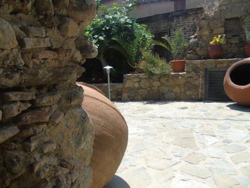 a stone wall with a large vase on a patio at Enipnion Apartments in Kakopetria