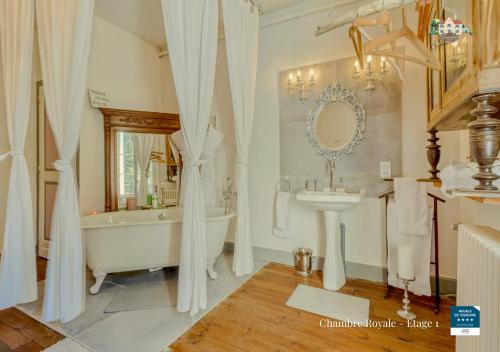 Un baño con bañera, lavabo y bañera. en Le Baccara Lodge, véritable maison de famille avec piscine et parc, en Arengosse