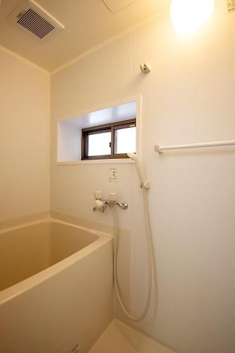 a bathroom with a bath tub and a window at M&T stay in Tokyo