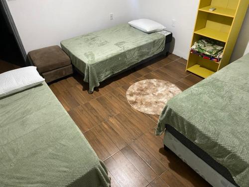 um quarto com 2 camas e piso em madeira em Alquiler en Piriapolis em Piriápolis