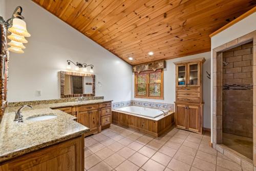een grote badkamer met een bad en een wastafel bij The Bears & Bees Lodge in Greens Mill