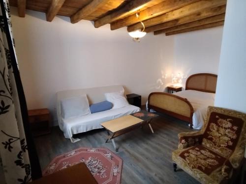 Cette chambre comprend deux lits, un canapé et une chaise. dans l'établissement Chambres Chez Marcel, à Spoy