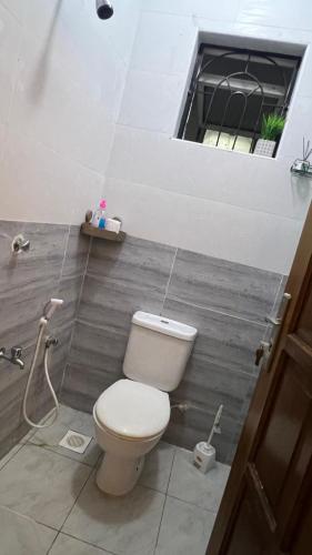 a bathroom with a toilet and a window at La Huésped in Mombasa