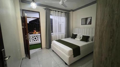a bedroom with a large bed and a window at La Huésped in Mombasa