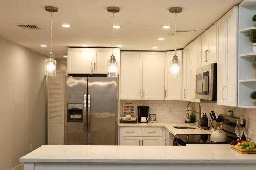 Una cocina con gabinetes blancos y un refrigerador de acero inoxidable. en Scenic View - Fire Pit - Near Legoland Woodbury Commons and the Castle, en Monroe