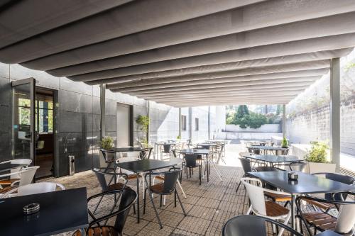 レサ・ダ・パルメイラにあるホリデイ イン エクスプレス ポルト エクポノールのパティオにテーブルと椅子があるレストラン