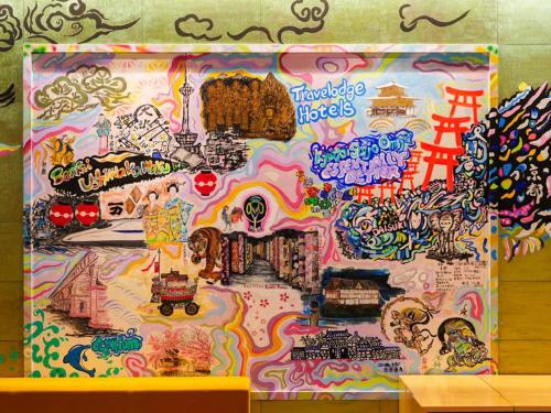 una pared cubierta de grafitis con una pintura encima en Travelodge Kyoto Shijo Omiya, en Kioto