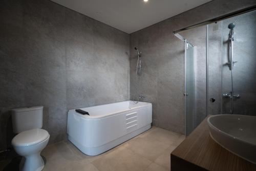 Un baño con bañera, inodoro y ducha. en ARA Stay By ARBA, en Bandung