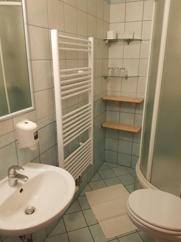 a white bathroom with a sink and a toilet at B&B Bau Maribor 3-star No Air Conditioning in Maribor