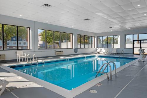 a large swimming pool with blue water in a building at Sleep Inn Indianapolis East in Indianapolis