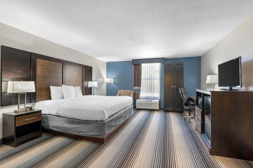 a hotel room with a bed and a flat screen tv at Sleep Inn Indianapolis East in Indianapolis