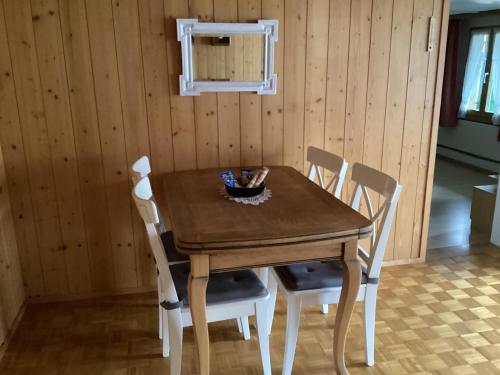 a wooden table with four chairs and a bowl on it at Mannried 2 1 2 Zimmerwohnung Rustikal in Zweisimmen