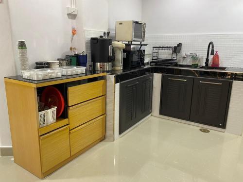 una cucina con banconi neri e piano di lavoro di Starhouse a Hat Yai