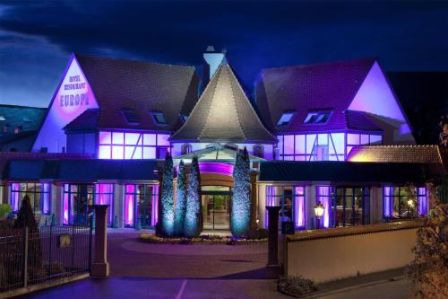 a building with purple lights on it at night at Hotel L'Europe Colmar, BW Signature Collection in Colmar